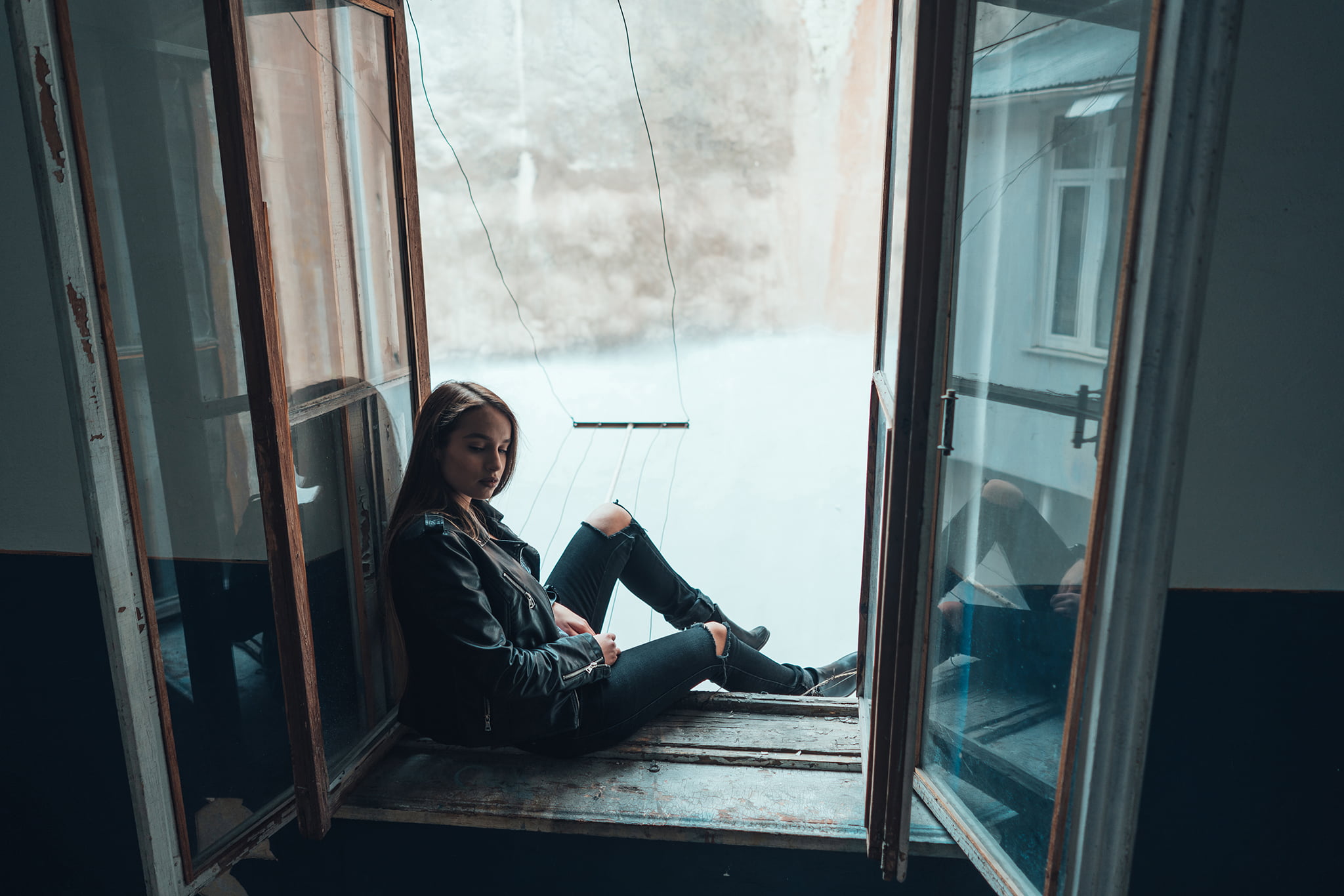 woman poses in a window